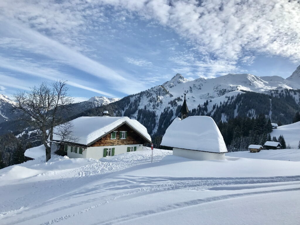 Skiurlaub mit Kindern Österreich - idyllisch mit den verschneiten Häusern 